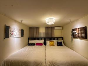 1 dormitorio con 1 cama grande y 2 almohadas en Yunseul- Garden House in the City with Korean Beauty, en Seúl