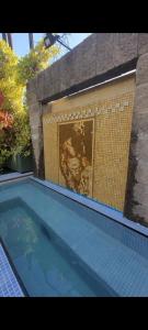a swimming pool in front of a brick wall at LGY G A Y Bed & Breakfast ONLY MEN in Buenos Aires