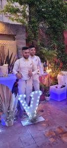 two men standing in front of a sign with a letter v at LGY Bed & Breakfast ONLY MEN-SOLO HOMBRES in Buenos Aires +69 photos