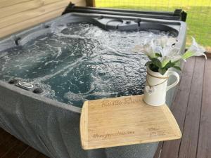 a hot tub with a vase of flowers on a table at River Dance by HoneyBearCabins in Sevierville