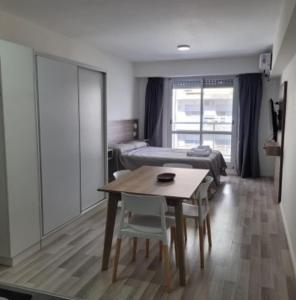 a room with a table and a bed and a bedroom at Alsina 125 in Junín