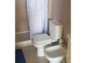 a bathroom with a white toilet and a sink at Alsina 125 in Junín