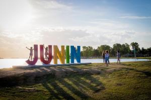 a group of people standing next to a sign that says join at Alsina 125 in Junín
