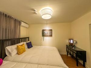 a bedroom with a large white bed and a lamp at Yunseul- Garden House in the City with Korean Beauty in Seoul