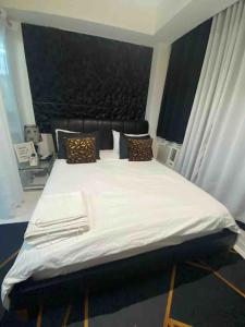 a bedroom with a bed with white sheets and pillows at Azure skyview 1BR netflix karaoke ps3 Airport in Manila