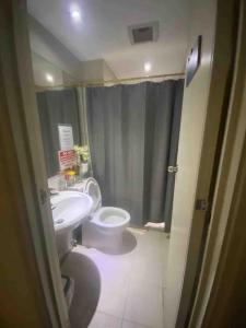 a bathroom with a sink and a toilet and a shower at Azure skyview 1BR netflix karaoke ps3 Airport in Manila