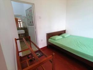 um pequeno quarto com uma cama e um espelho em 360 Mount Villa - Peacock Hill em Gampola