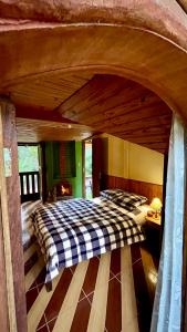 Pousada Céu Aberto - Visconde de Mauá - Maringá MG في إيتاتيايا: غرفة نوم بسرير كبير بسقف خشبي