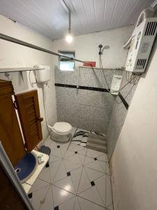 a small bathroom with a toilet and a shower at Tres Lunas Alojamiento Doble in Chuy