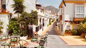 an empty street with tables and chairs in an alley at El Muro in Benalmádena