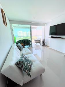 sala de estar con sofá blanco y TV en Apartamento con vista al mar en Santa Marta, en Santa Marta