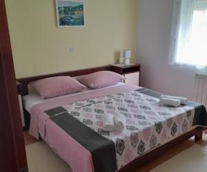 a bedroom with a bed with two pink pillows at Apartments with a parking space Selce, Crikvenica - 2361 in Selce