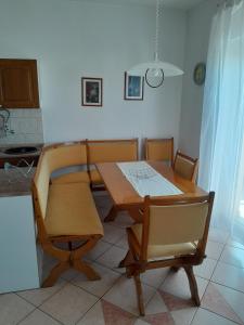 a table and chairs in a room with a kitchen at Apartments with a parking space Selce, Crikvenica - 2361 in Selce