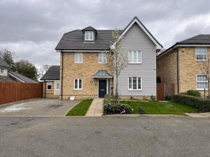 a large brick house with a driveway at Enfield's Premier Holiday Oasis in Waltham Abbey