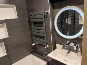 a bathroom with a sink and a mirror at Enfield's Premier Holiday Oasis in Waltham Abbey