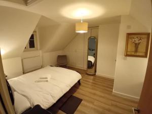 a bedroom with a white bed and a staircase at Enfield's Premier Holiday Oasis in Waltham Abbey