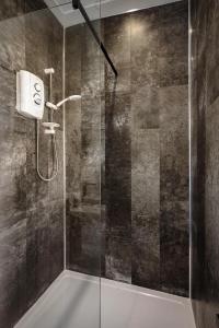 a shower with a glass door in a bathroom at No4 Garlands Apartment in Saint Annes on the Sea