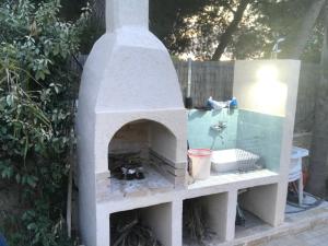 un forno in pietra con lavandino in un cortile di Librari - Quality confort a Torre Ovo