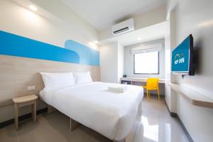 マニラにあるHop Inn Hotel North EDSA Quezon Cityのベッドルーム(大きな白いベッド1台、黄色い椅子付)
