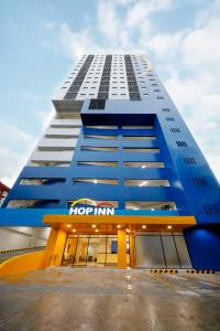 un gran edificio azul con un cartel de posada de lúpulo en él en Hop Inn Hotel North EDSA Quezon City en Manila