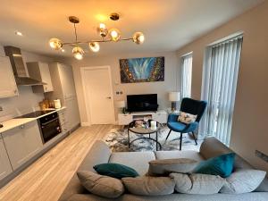 a living room with a couch and a kitchen at Luxurious Flat at Leicester Town in Leicester