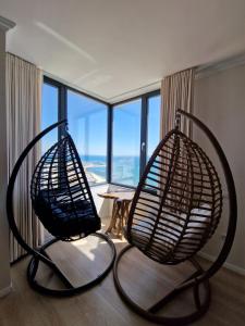 two metal chairs in a room with a large window at Absolut Vollga in Durrës