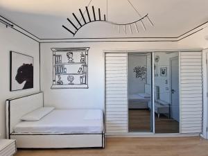 a white room with a bed and a mirror at Absolut Vollga in Durrës