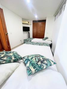 Habitación pequeña con 2 camas y paredes blancas. en Apartamento con vista al mar en Santa Marta, en Santa Marta