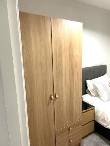 a large wooden cabinet next to a bed at Ekaya Cozy Home in Belfast