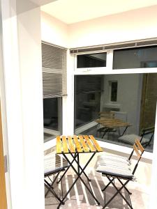 a patio with a table and chairs on a balcony at Ekaya Cozy Home in Belfast