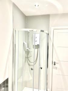 a shower with a glass door in a bathroom at Ekaya Cozy Home in Belfast