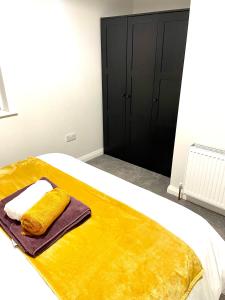 a bedroom with a bed with a yellow blanket at Ekaya Cozy Home in Belfast