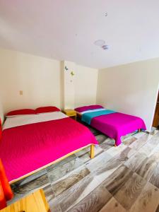 2 camas en una habitación con sábanas de colores vivos en Hostal Don Jose, en Santa Rosa de Cabal