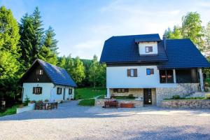 a large white house with a blue roof at Rooms with a parking space Jezerce, Plitvice - 22116 in Plitvička Jezera