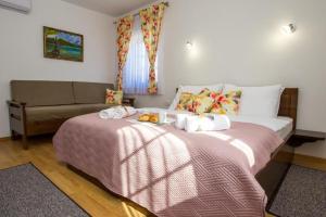 1 dormitorio con 1 cama grande y 1 sofá en Rooms with a parking space Jezerce, Plitvice - 22116, en Lagos de Plitvice
