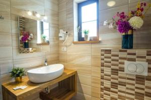 baño con lavabo, espejo y flores en Rooms with a parking space Jezerce, Plitvice - 22116, en Lagos de Plitvice