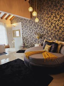 - une chambre avec un grand lit et du papier peint floral dans l'établissement Hotel Mansión Sant Serrant, à Marinilla
