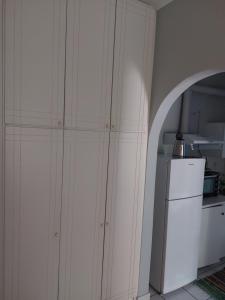 a kitchen with a white cabinet next to a refrigerator at Marilena Rooms Plataria in Plataria +15 photos