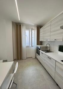 cocina con armarios blancos y ventana grande en Casa Vacanza Trecastelli Senigallia (AN), en Trecastelli