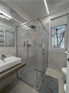 y baño con ducha y lavamanos. en Casa Vacanza Trecastelli Senigallia (AN), en Trecastelli