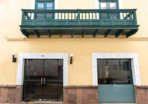 a balcony on the side of a building with two doors at Hotel Raymi in Cusco