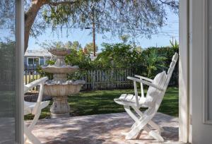 dos sillas blancas sentadas junto a una fuente en 3 Bedroom House - Fire Pit Table BBQ - 10 Guests, en La Mesa