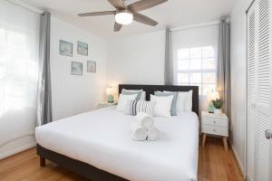 una camera da letto con un grande letto bianco con due asciugamani di 3 Bedroom with Ocean View Jacuzzi and Parking a San Diego