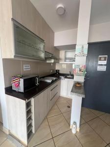 a kitchen with a sink and a microwave in it at Trendy Mini Apartment in Miraflores in Lima