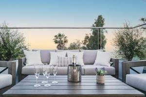 a table with wine glasses and a couch on a patio at 3 Bedroom with Ocean View Jacuzzi and Parking in San Diego
