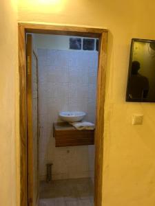 ein Bad mit einem Waschbecken und einem Spiegel in der Unterkunft ETOUDI in Douala