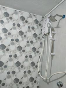 um chuveiro com secador de cabelo na casa de banho em Homestay Ummie 