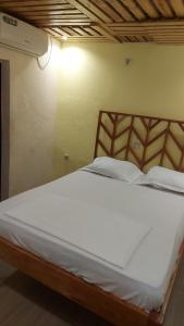 a large white bed in a room with a light at ETOUDI in Douala