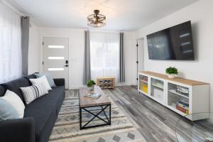 a living room with a couch and a tv at 3 Bed House with Fire Pit Table and BBQ - Downtown in San Diego