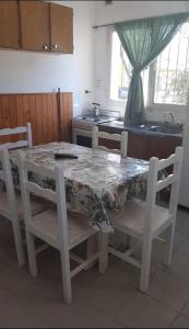 a kitchen with a table and chairs with a table and a sink at Ruka Leufu in Santa Rosa de Calamuchita
